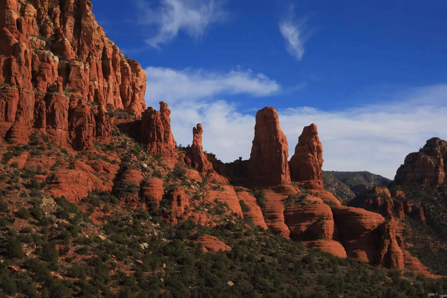 Red rock spires rise under a blue sky in Sedona, Arizona.