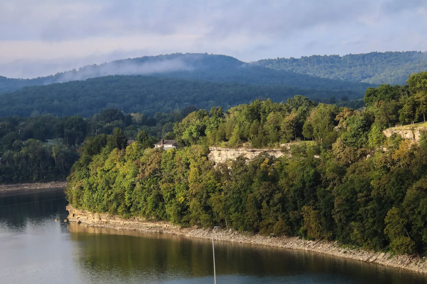Forested bluffs rise from a calm lake in the Ozark Mountains of Arkansas.