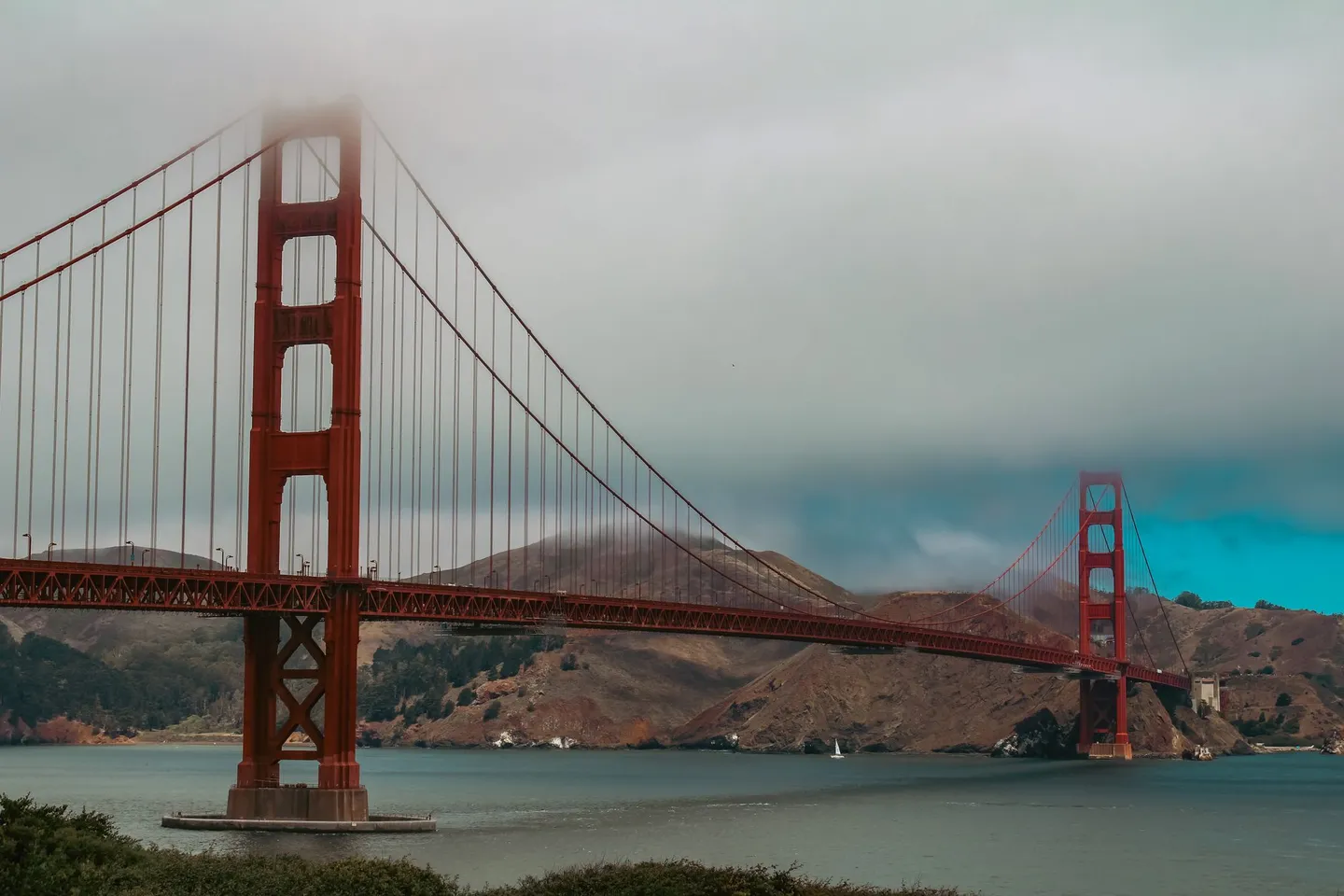 The Golden Gate Bridge crosses San Francisco Bay under low mist in California.
