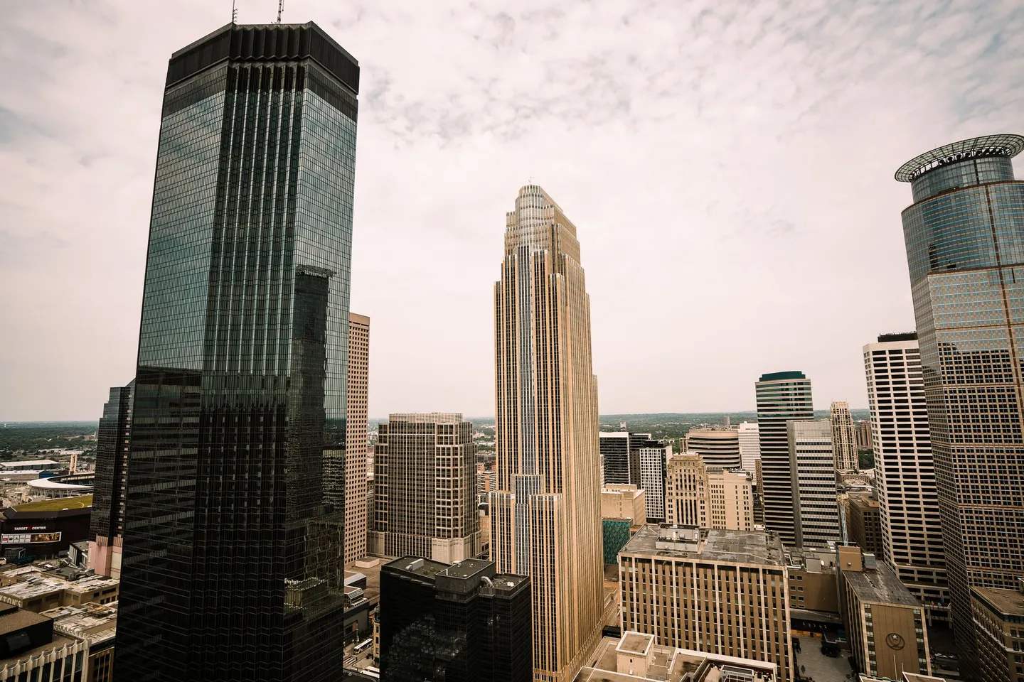 Downtown Minneapolis skyscrapers, including the Wells Fargo Center, rise under a hazy sky in Minnesota.