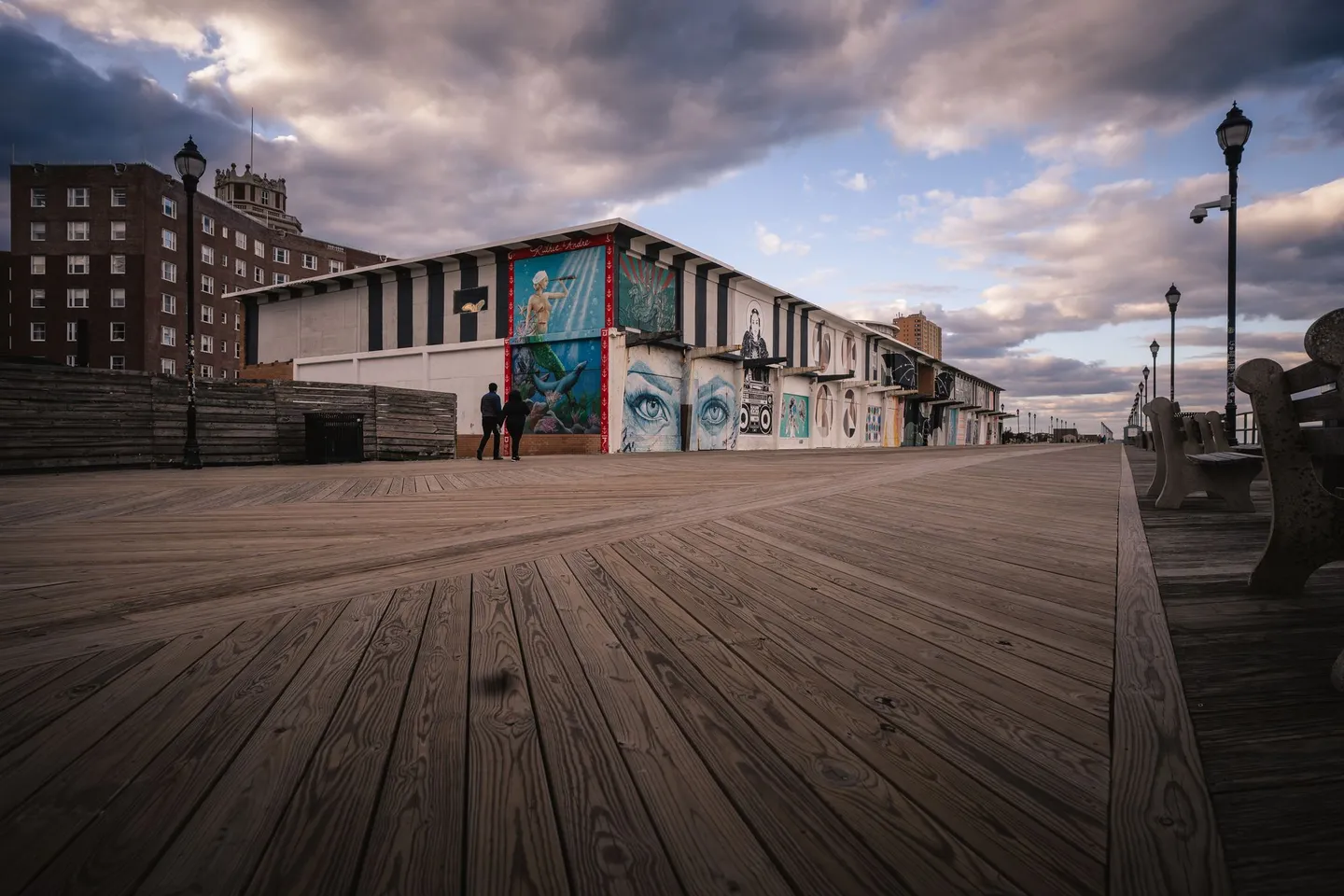 The wooden boardwalk and murals at Asbury Park on the New Jersey shore under a dramatic sky.