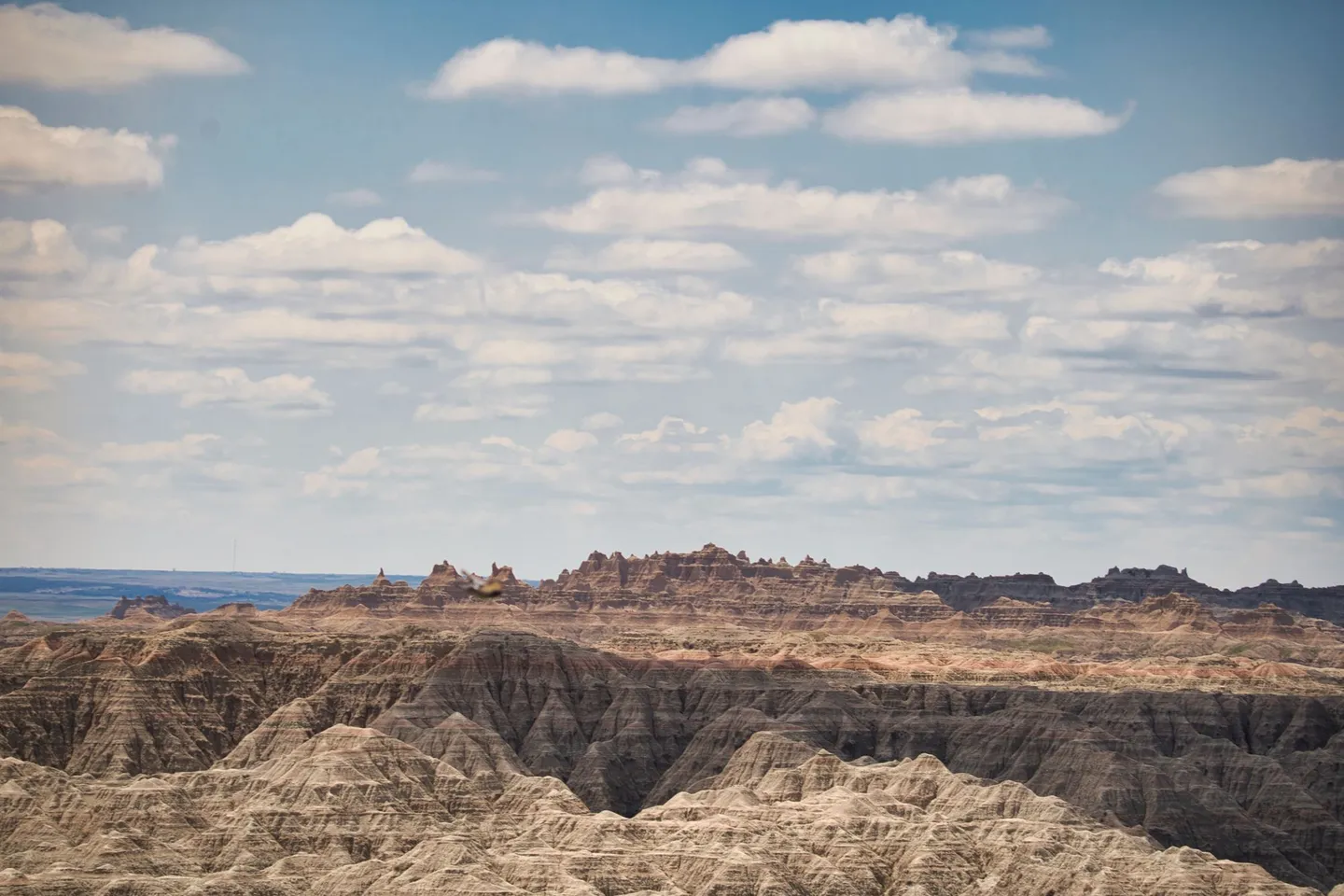 Eroded ridges stretch under a cloudy sky in Badlands National Park, South Dakota.