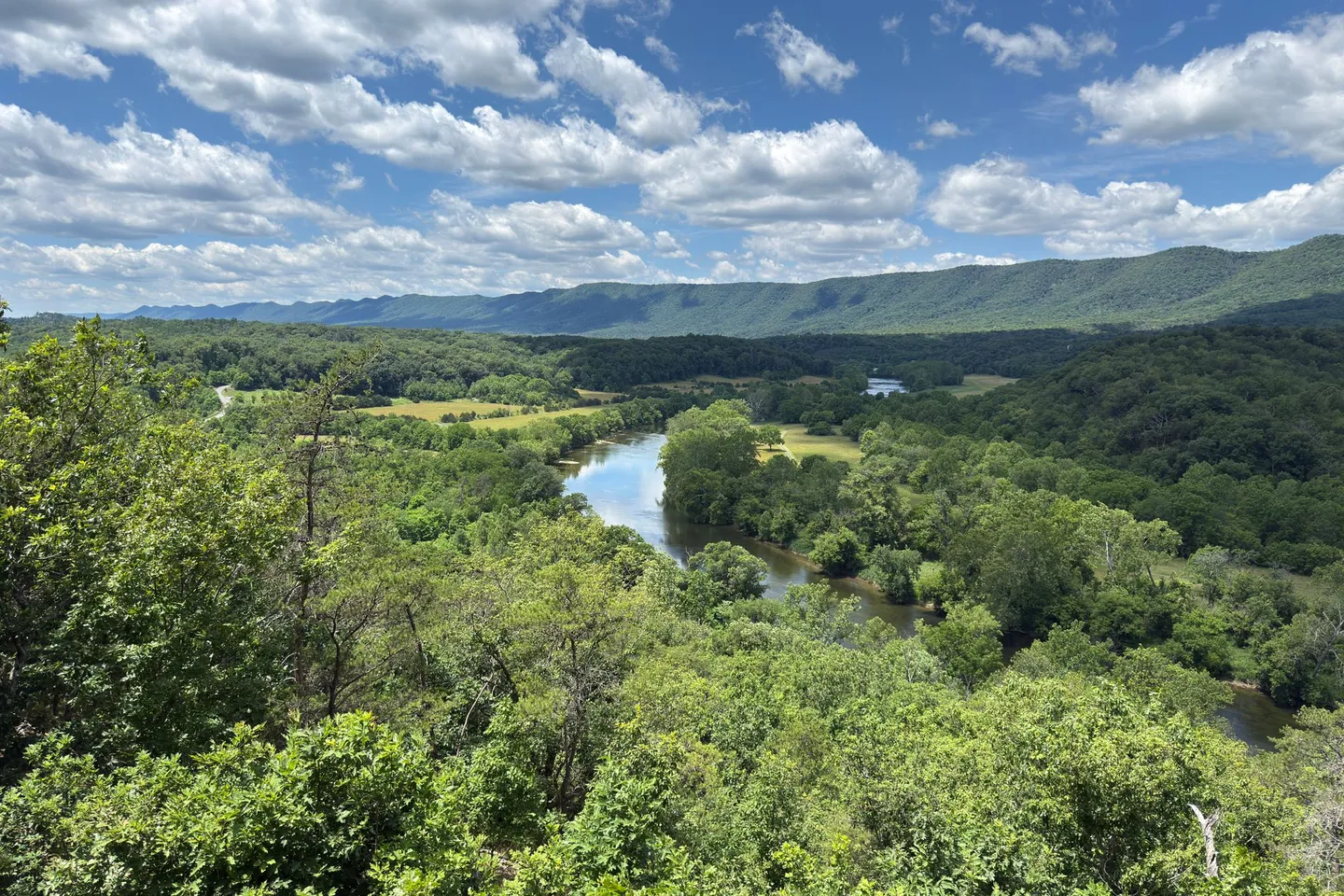 The Shenandoah River winds through green forest below the Blue Ridge Mountains in Virginia.