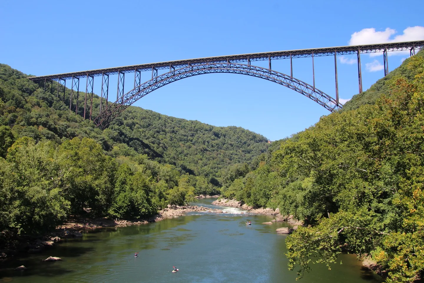 The New River Gorge Bridge spans a forested valley and river in West Virginia.